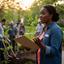 Aisha Williams holding a clipboard at a neighbourhood planting event